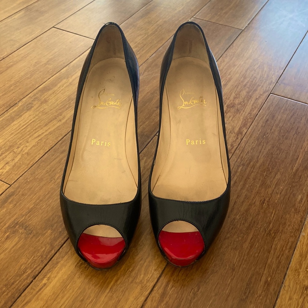 Christian Louboutin black leather heels with red peep toe.